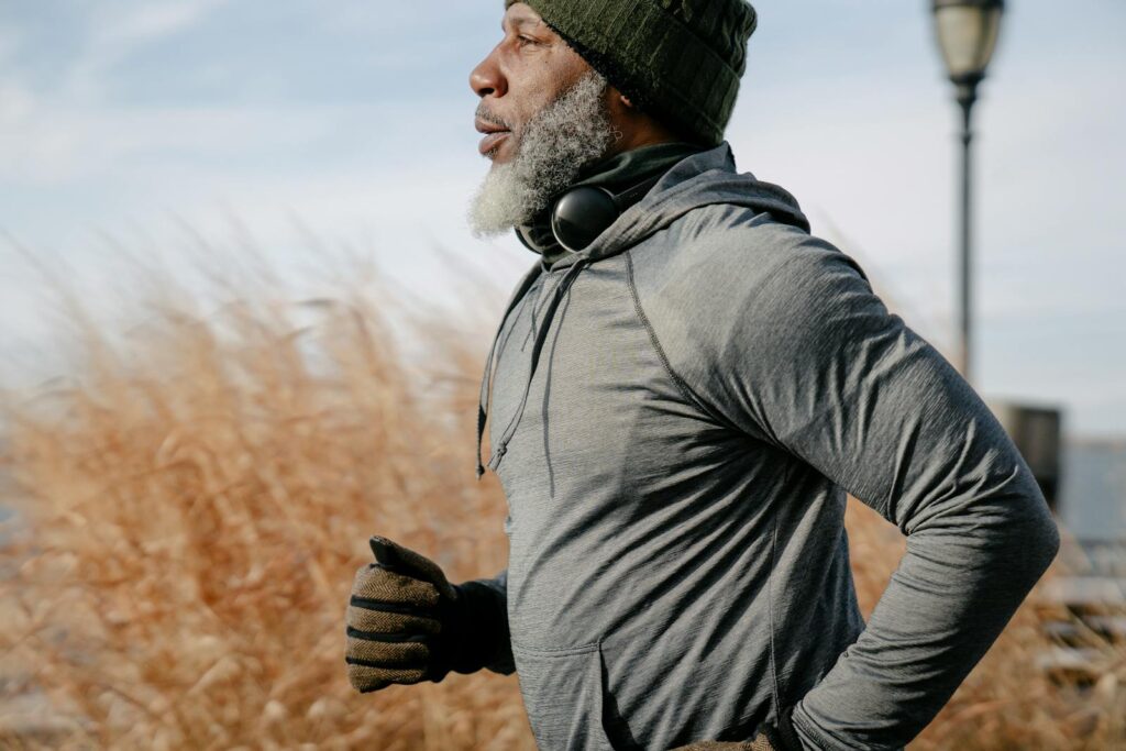 Man in sportswear jogging in sunny autumn day