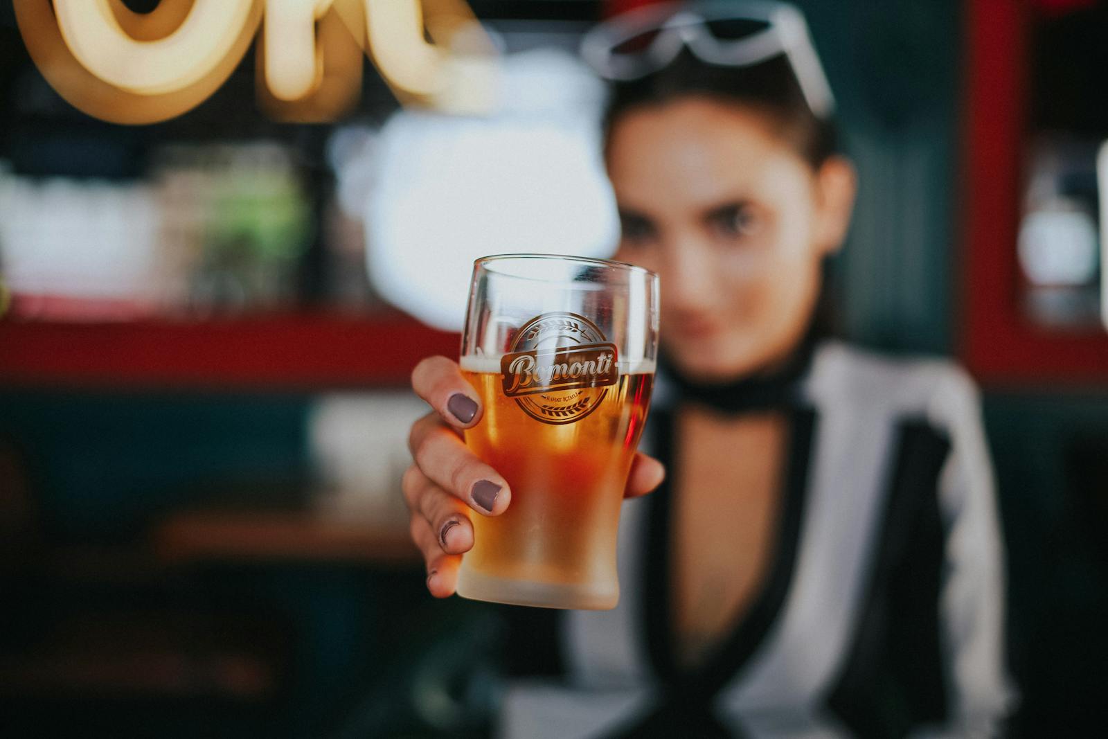 Close-up of Womans Hand Holding Glass of Beer