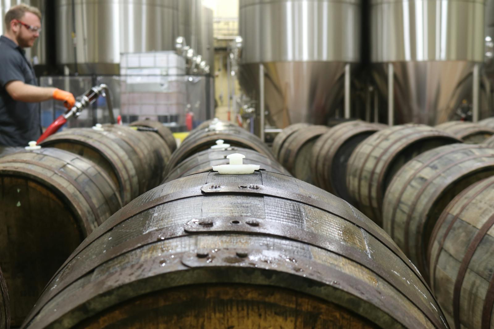 Wooden barrels in a brewery for beer fermentation. Industrial setting.